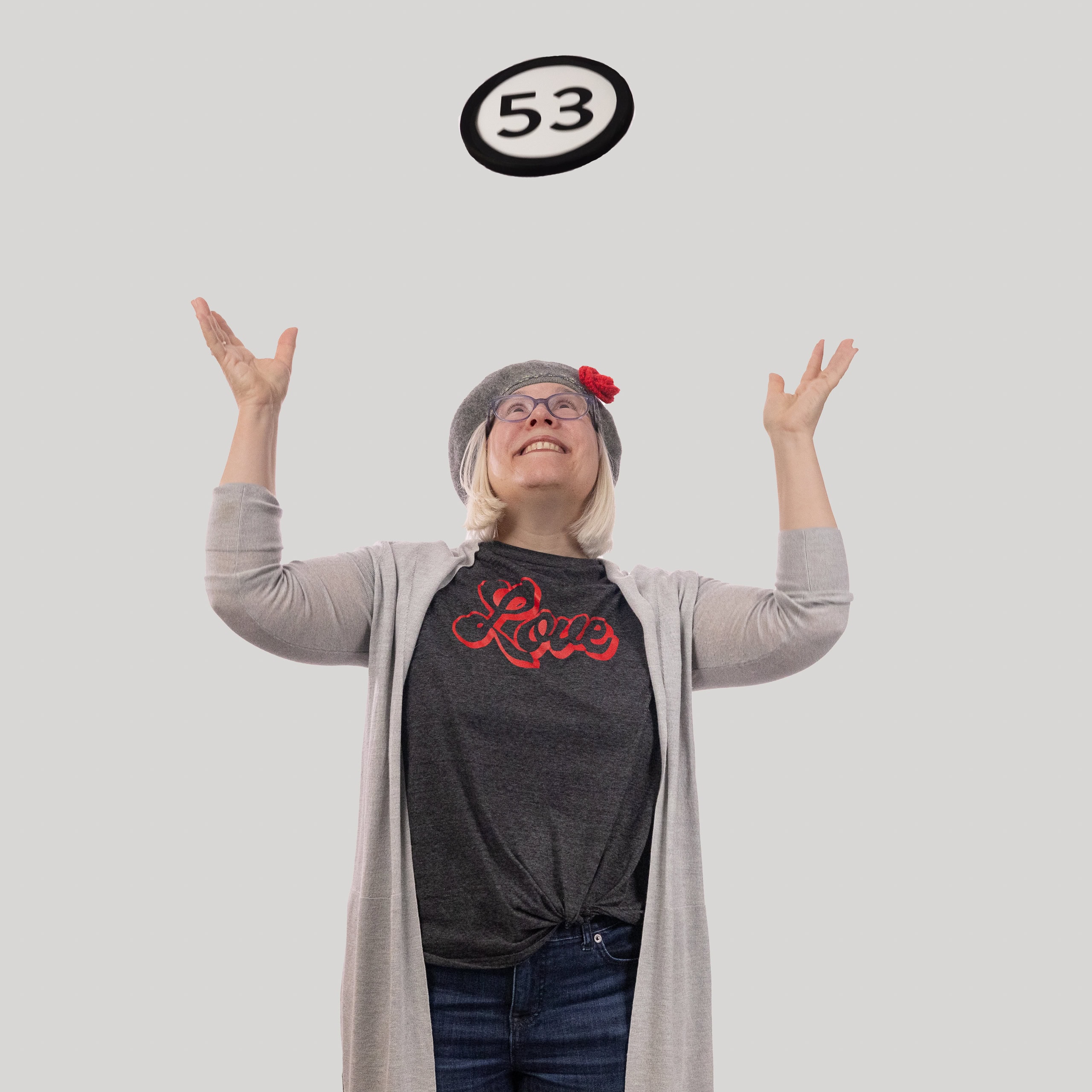 53-year-old woman holds the number 53 in the 1 to Infinity, MIT portrait series by Danny Goldfield.
