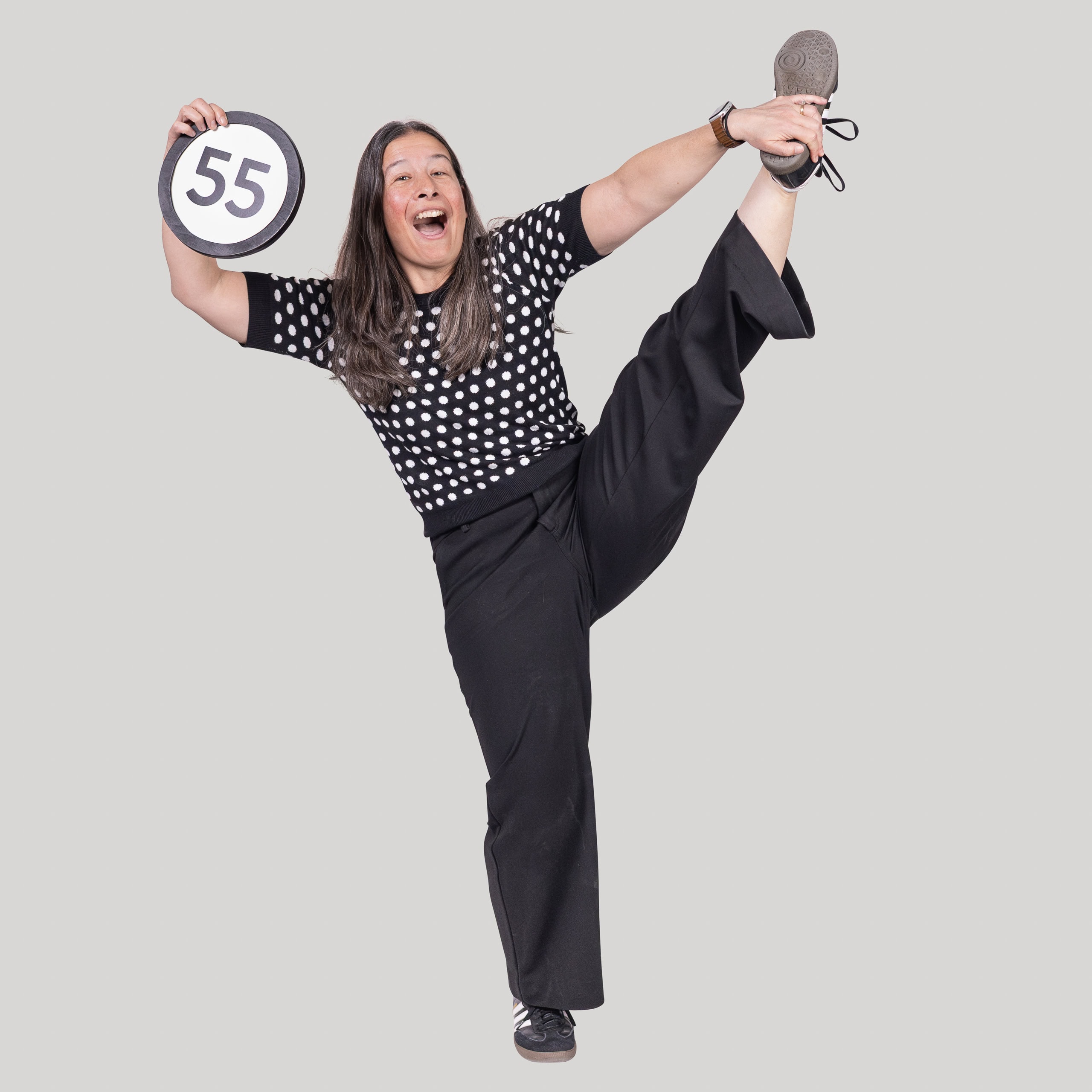 55-year-old woman holds the number 55 in the 1 to Infinity, MIT ortrait series by Danny Goldfield.